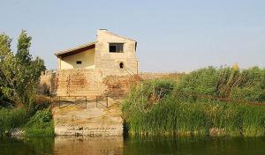 un edificio sentado a un lado de un cuerpo de agua en Casa rural khaleesi, en El Carpio de Tajo