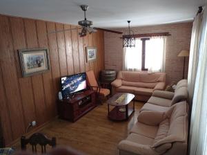 - un salon avec un canapé et une télévision dans l'établissement Casa rural khaleesi, à El Carpio de Tajo