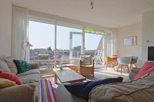 a living room with couches and a living room with a view at Residence de L'Europe - Baddomburg in Domburg