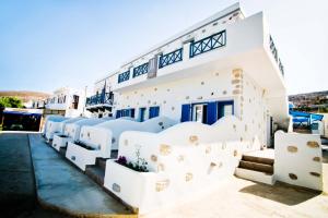a white building with a bunch of white chairs at Nammos Sunset in Psérimos