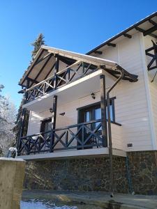 ein Haus mit einem Balkon an der Seite in der Unterkunft Villa Medova in Kossiw