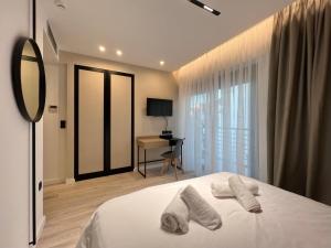 a bedroom with a bed with two white towels on it at ICON Urban Living in Thessaloniki
