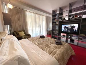By Best Apartments في تيرانا: غرفة نوم بسرير وتلفزيون بشاشة مسطحة