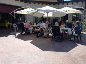 a group of people sitting at tables under umbrellas at Villa Bellevue in Waldkappel