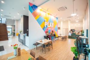a living room filled with furniture and a table at Play Poshtel & Cafe' in Krabi town