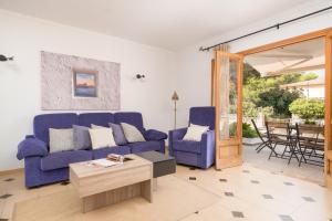 a living room with blue couches and a table at Villa Manresa in Alcudia