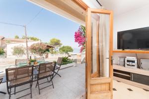 an open door to a patio with a table and a television at Villa Manresa in Alcudia