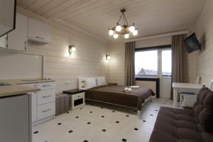 a bedroom with a bed and a kitchen with a sink at Villa Medova in Kosiv