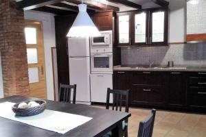 a kitchen with a table and a white refrigerator at Casa de pueblo con encanto in Tarragona