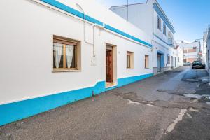 une rue vide avec un bâtiment blanc et bleu dans l'établissement A ca da Paolina, à Calasetta
