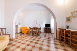 sala de estar con arco, mesa y sillas en A ca da Paolina, en Calasetta