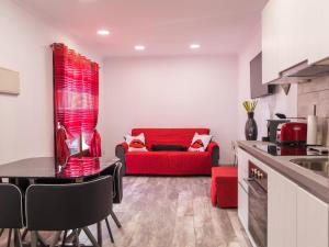a kitchen and living room with a red couch at SUNSET RUBY ,1 Bedroom, SWIMMING POOL in Caleta De Fuste