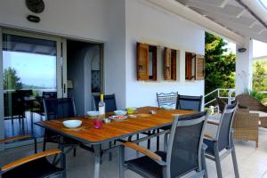 a wooden table and chairs on a patio at Villa Paparouna in Magaziá