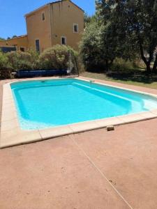 una gran piscina azul frente a una casa en Chalet d'une chambre avec piscine partagee et jardin amenage a Cornillon Confoux, en Cornillon-Confoux