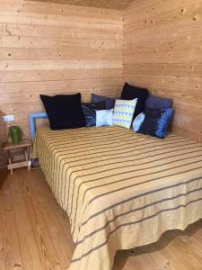 1 dormitorio con 1 cama grande en una pared de madera en Chalet d'une chambre avec piscine partagee et jardin amenage a Cornillon Confoux, en Cornillon-Confoux