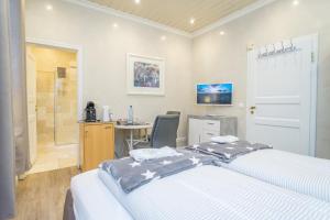 a bedroom with two beds and a desk and a shower at Rumpelstilzchen in Westerland