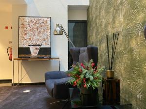 a living room with a blue chair and a lamp at Lux Housing Século XXI in Braga