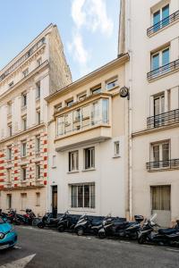 une rangée de motocycles garés devant un bâtiment dans l'établissement Edgar Suites Auteuil - Le Marois, à Paris