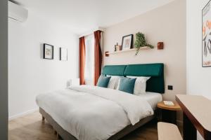 a bedroom with a large bed with a green headboard at Edgar Suites Auteuil - Le Marois in Paris