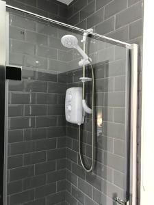 a shower with a shower head in a bathroom at CLIFTON Apartments in Liverpool