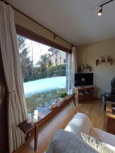 a living room with a large window and a couch at HORT DE CAL BENET in Urus