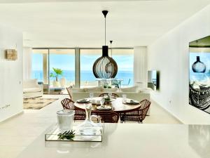 uma sala de jantar e sala de estar com mesa e cadeiras em Stupa Hills - Superb Luxury Apartment Sea Views em Benalmádena
