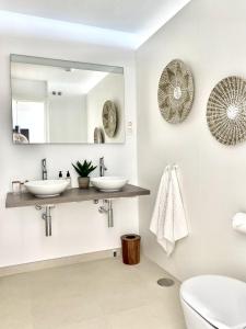 a bathroom with two sinks and a mirror at Stupa Hills - Superb Luxury Apartment Sea Views in Benalmádena