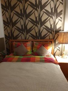 a bedroom with a bed with a wall with trees at Apartament City Center - 24 h contactless self check-in, no smoking, free bottled water, coffee and tea in Koszalin