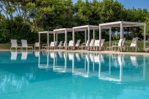 a group of chairs sitting next to a swimming pool at Masseria Mongiò dell'Elefante in Otranto