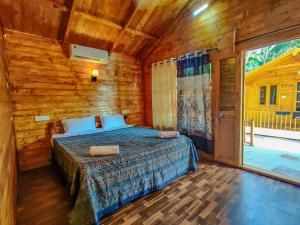 una camera da letto con un letto in una cabina di legno di Next ta Sea a Palolem