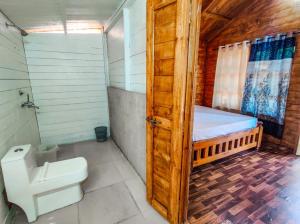 a bathroom with a toilet and a bed in it at Next ta Sea in Palolem