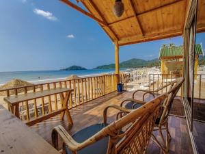 una terrazza con panchine e vista sulla spiaggia di Next ta Sea a Palolem