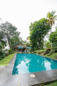 a swimming pool in front of a house at Glenross Living in Kalutara
