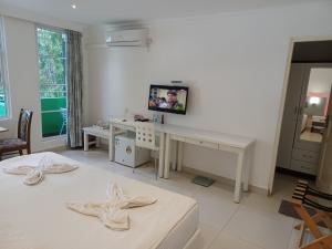 a bedroom with a bed and a desk and a television at Beach Grand & Spa Premium in Hulhumale