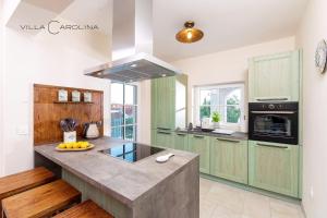 a kitchen with green cabinets and a counter top at Villa Carolina in Izola