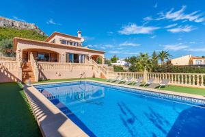 a villa with a swimming pool in front of a house at Villa Amanda - PlusHolidays in Calpe