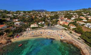 an aerial view of a beach with people in the water at Villa Castillo - PlusHolidays in Benissa