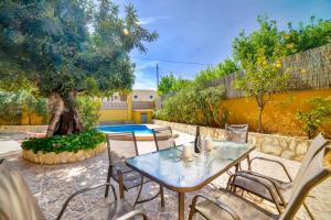 a patio with a table and chairs and a tree at Villa Alexandra - PlusHolidays in Calpe