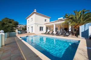 a villa with a swimming pool in front of a house at Villa Malibu - PlusHolidays in Moraira