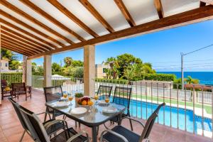 a patio with a table and chairs and a pool at Villa Dorada - PlusHolidays in Calpe