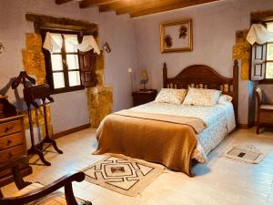 Schlafzimmer mit einem Bett, einer Kommode und Fenstern in der Unterkunft Casa Rural Molino de Luna in Soncillo