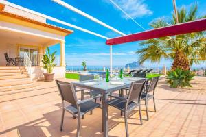 a table and chairs on a patio with a view of the ocean at Villa Maximo - PlusHolidays in Calpe