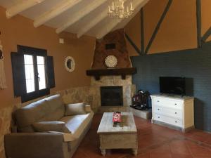 a living room with a couch and a fireplace at El Chozo in Fuentidueña