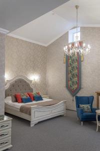 シャフティにあるБутик-отель Замокのベッドルーム1室(大型ベッド1台、シャンデリア付)