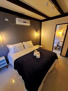 a bedroom with a large bed with two towels on it at Pousada Estrela Cordel in Fernando de Noronha