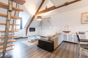 een woonkamer met een bank en een trap bij Duplex in Saint-Malo