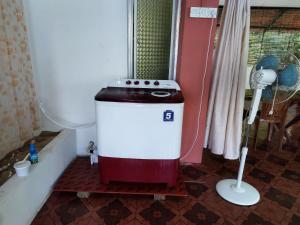 y baño con lavadora y ventilador. en The Leisure Home Stay en Shādipur