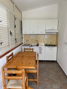 a kitchen with a wooden table and white cabinets at A&d in Carrao