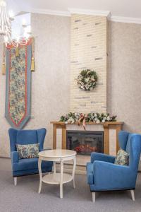 シャフティにあるБутик-отель Замокのリビングルーム(青い椅子2脚、暖炉付)