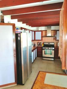 a kitchen with a refrigerator, stove, sink and cabinets at Villa Florie Guest House - Economic Rooms in Sosúa